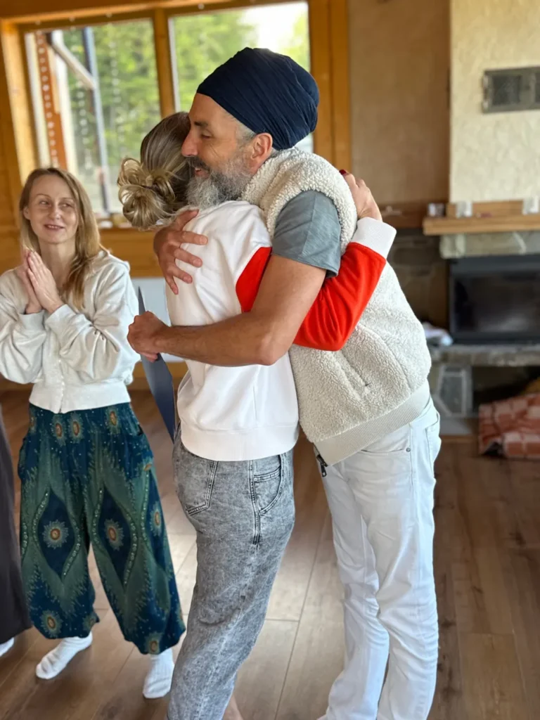 Teacher embracing a student at the end of a Kundalini Yoga training
