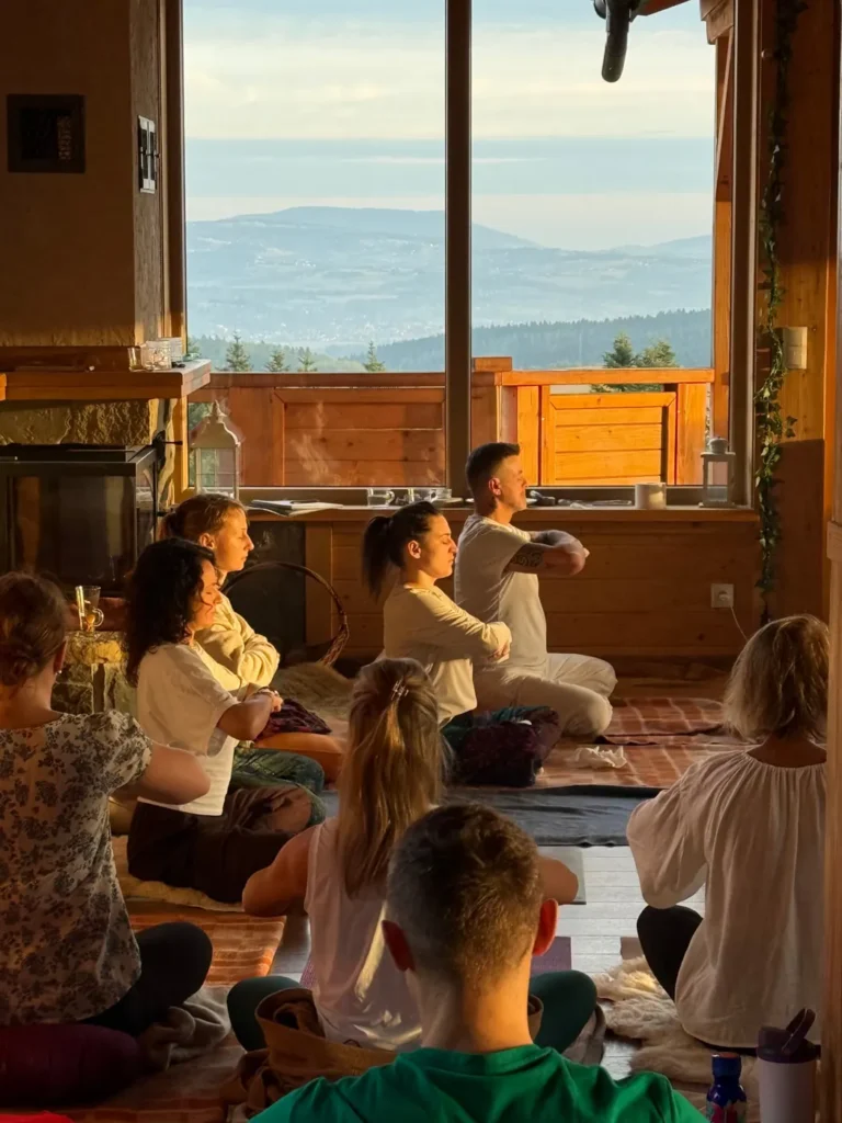 Group meditation at sunrise with a view over the mountains